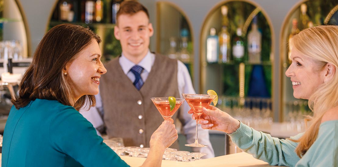 Two women enjoying drinks in Belvedere Lounge Bar aboard Spirit of the Danube